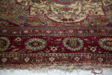 The finely woven floral border and mostly secure end of an antique silk Mohtashem Kashan rug.