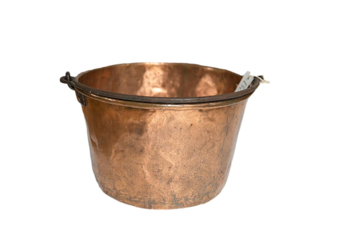 Antique hammered copper apple butter kettle with blacksmithed handle and rich, aged patina.