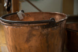 Dark blacksmithed handle and rolled rim of the antique hammered copper apple butter kettle.