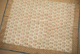 Corner detail of early Persian brocade: delicate pink florals, patterned border, and subtle blue edge.
