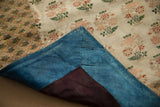 Antique Persian brocade textile corner, revealing its blue original backing and delicate floral pattern.