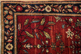 Navy serpent border with floral motifs beside the abrashed red field of an antique Farahan Sarouk rug.