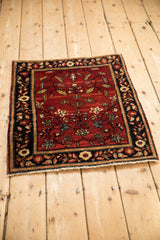 A high-angle view of the antique Farahan Sarouk rug showing its full tree of life design.