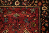 Corner view of an antique Farahan Sarouk showing the serpent border and starburst floral blossoms.