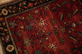 Serrated leaves and starburst blossoms on the low, abrashed pile of an antique Farahan Sarouk rug.