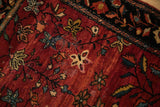 Corner view of an antique Farahan Sarouk showing its worn floral field and serpent border.