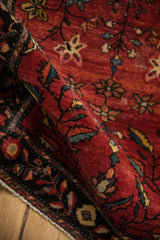 Low, hand-knotted pile of an antique Farahan Sarouk rug showing the texture of its abrashed red field.