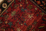 Floral motifs and storied wear on an antique Farahan Sarouk's abrashed cherry red pile.
