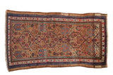 Antique Serab carpet featuring interconnected geometric medallions and gem tones on a camel ground.