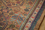 Reciprocating pawn design border alongside intricate field motifs of an antique Serab carpet.