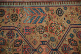 Detailed view of the intricate pomegranate motifs and pawn design border on a fine antique Serab carpet.