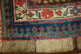 Restored corner of an antique Serab carpet showing the pawn design border and time-softened wool pile.