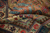 Soft, high-grade wool pile with gem-toned geometric motifs on a folded antique Serab carpet.