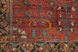 Detail of a Collector Farahan Sarouk rug's brick-red field with jade green and saffron floral vines.
