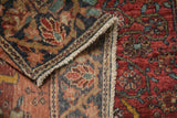 Folded corner of a vintage Farahan Sarouk rug reveals its hand-knotted weave and side cord selvage.