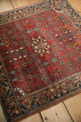A vintage Farahan Sarouk rug corner showing the intricate floral border and dense, brick-red field.