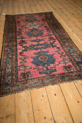 Angled view of a vintage Persian Mehriban rug showing the texture of its magenta and blue floral design.