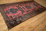 Vintage Mehriban rug from a side angle, showing the oversized blue medallions and slight rippling.