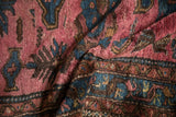 Soft, varied pile of a hand-knotted Persian rug in shades of magenta and sapphire blue.