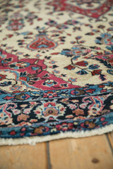 Close view of the palmette and boteh motifs in the dark main border of an antique Sarouk rug.