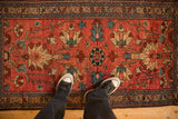 The scale of an antique Mehreban rug's large floral palmettes on a raspberry red field.