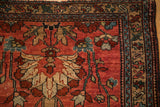 Worn corner of an antique Mehreban rug with geometric floral borders in teal and brown.