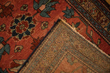 Corner of an antique Mehreban rug folded back to show the detailed hand-knotted foundation.