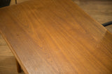 Close-up of the vintage teak coffee table's surface showing its warm wood grain and patina.