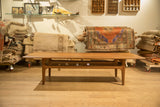 Vintage teak coffee table with sled base and full-length woven rattan shelf.