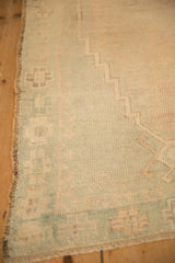 Detail of the vintage Oushak rug's secured side cord selvage and worn, low pile.