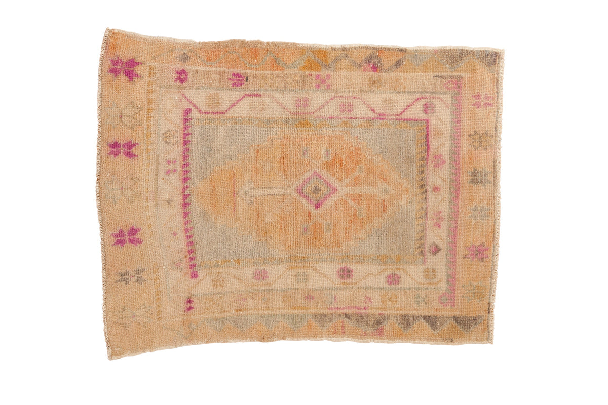 Distressed vintage Oushak rug with a central diamond medallion in dusty gold, oxidized silver, and magenta.