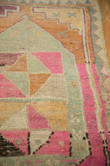 Close-up of the evenly worn pile on a distressed Kars rug, highlighting pink, silver, and orange geometric patterns.