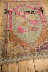 Low-pile texture of a distressed Kars rug featuring stepped geometric patterns in pink, orange, and silver.