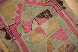 Close-up of the distressed pile showing hand-knotted texture in pink, silver, and sandalwood geometric motifs.