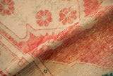 Abrashed pomegranate red and floral details on the distressed, low pile of a vintage Oushak rug.