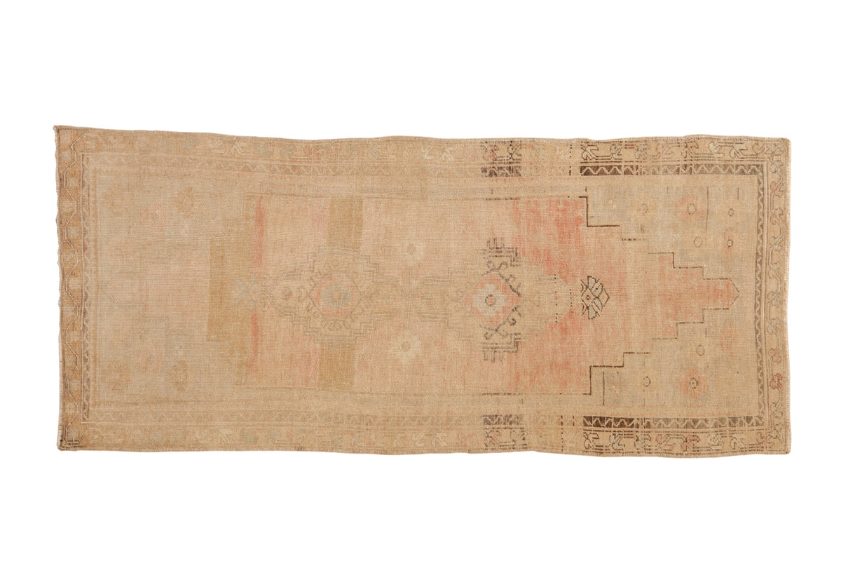 Vintage distressed Oushak rug runner with stepped medallions in faded dusty rose, beige, and silver tones.