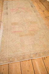 Angled view showing the distressed Oushak runner's low pile and soft, abrashed colors.