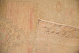 Hand-knotted construction and tidy weave visible on the reverse of the distressed Oushak rug.