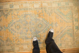 Worn, low-pile texture of a vintage distressed Oushak rug in saffron and faded turquoise, shown for scale.