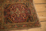 Angled view of a Farahan Sarouk rug showing its perched bird corner designs and aged patina.