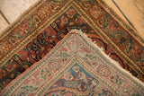 The hand-knotted reverse weave and worn corner of a vintage Persian Farahan Sarouk rug mat.