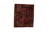 Antique Persian Lilihan sampler rug with a floral bouquet and vine border on a burgundy field.