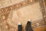Looking down at the time-softened texture and low pile of a distressed Turkish Oushak rug.