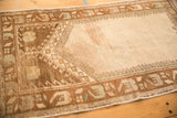 Corner of a distressed Oushak rug showing the geometric mehrab and low pile texture.