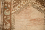 Close-up of a distressed Oushak rug's prayer arch and geometric border in earthy tones.