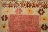 Distressed pile texture on a vintage Anatolian rug with madder red field and floral motifs.