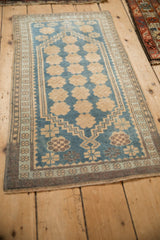 Angled perspective of a distressed Turkish Oushak rug with rows of floral blossoms.