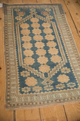 Angled view of a vintage Oushak rug with even wear over its sky blue and ivory floral columns.