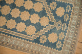 The stepped lozenge design and floral blossom border of a vintage Oushak rug.