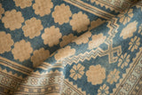 Folded view revealing the even wear and floral pattern of a distressed Oushak rug.